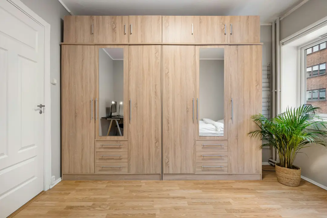 A bedroom with a bed and a wooden closet