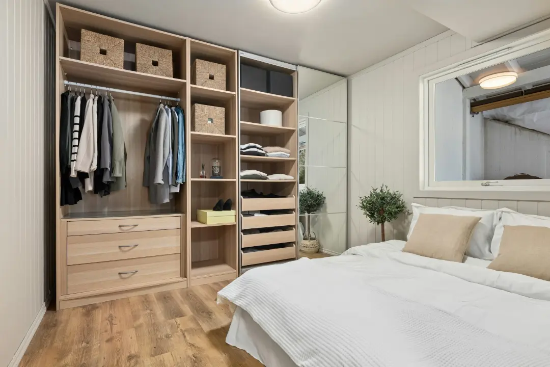 A bedroom with a bed, mirror and closet