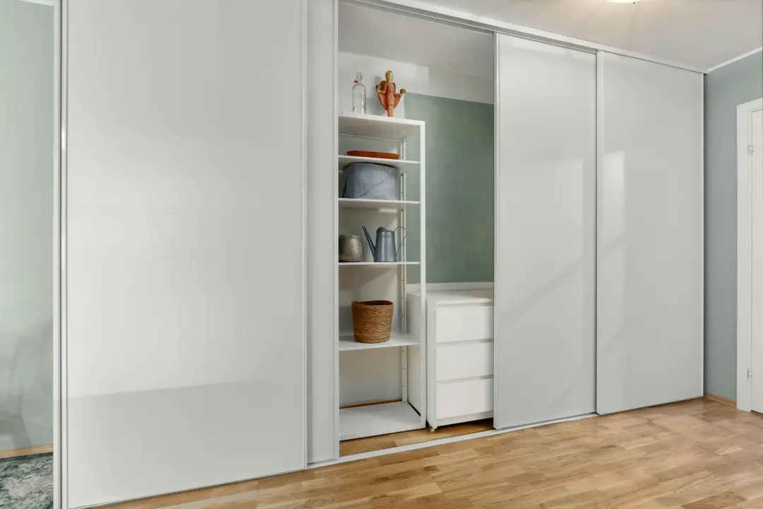 A room with a wooden floor and white closets