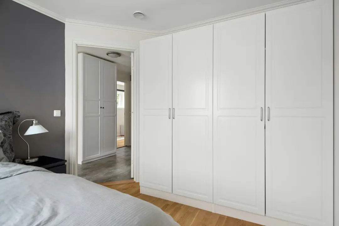 A bedroom with a bed and white cabinets
