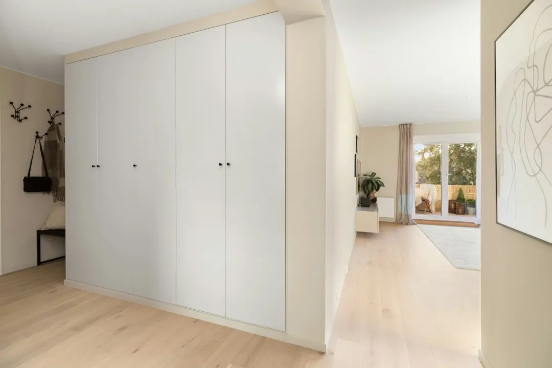 A living room with a large white cabinet next to a window